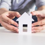 businessmen hold house model in hand