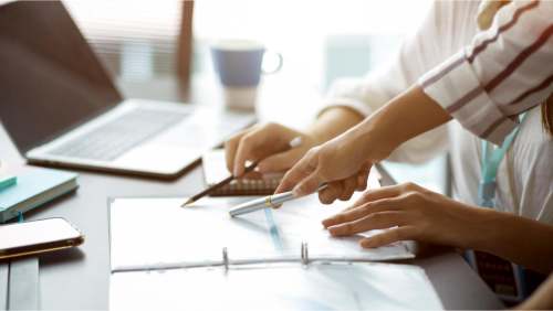 cropped-image-two-businesswomen-discuss-voting-business-strategy-plan-project-pen-pointing-papers